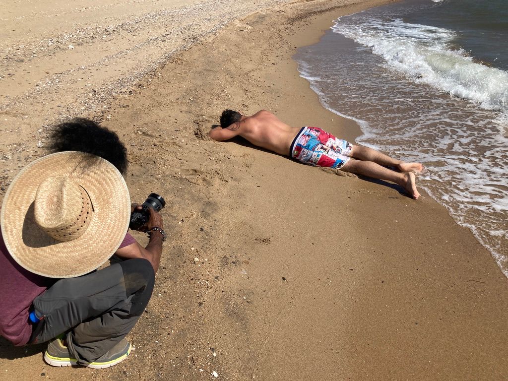 A person lies face-down in the sand after ingesting 5-MeO-DMT as part of one of Octavio’s sessions, as a volunteer assistant and patient takes a photo.